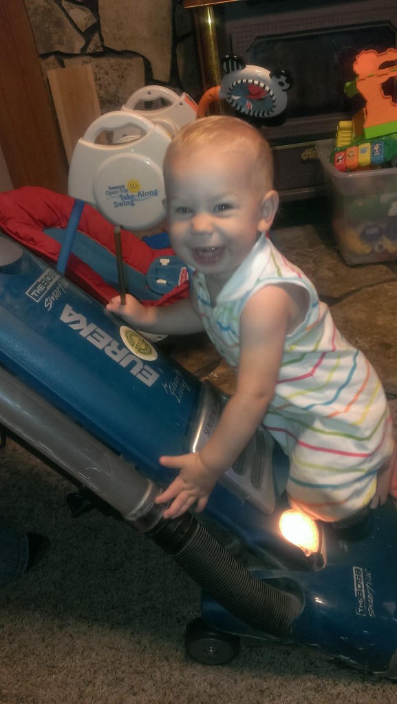 One Year Old riding the vacuum cleaner.